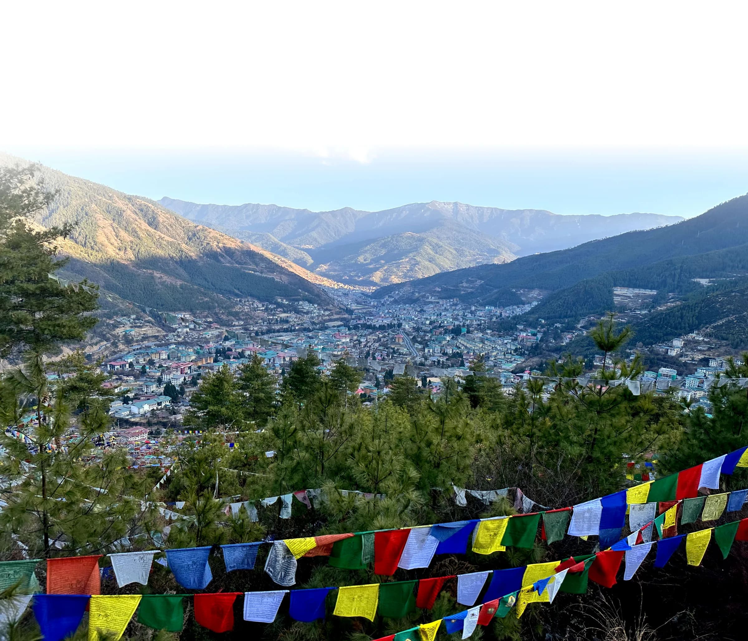 Prayer flags strung above the pine slopes overlooking Thimphu, the valley town and the Himalayan foothills beyond