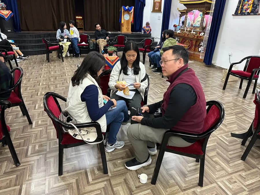 ELC students and staff seated in a circle on the hall floor during a facilitated session