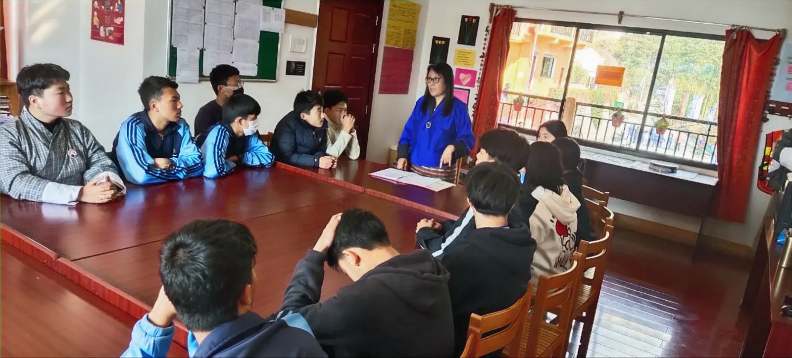 ELC students and a trained facilitator seated around a table in a circle, mid-conversation