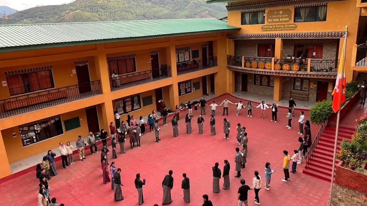 The whole school standing in one large circle around the courtyard, seen from the balcony above